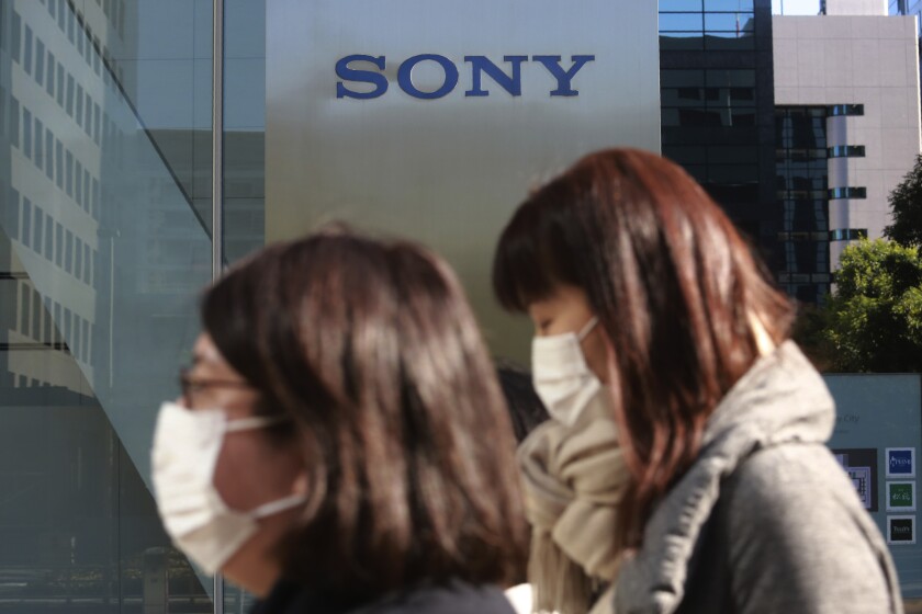 People walk past the headquarters of Sony Corp. in Tokyo, Wednesday, Feb. 3, 2021. Sony Corp. reports its fiscal third quarter profit jumped 62%, positioning the Japanese entertainment and electronics giant for a record annual profit as its bottom line got a healthy boost from its mega-hit animation film “Demon Slayer.” (AP Photo/Koji Sasahara)