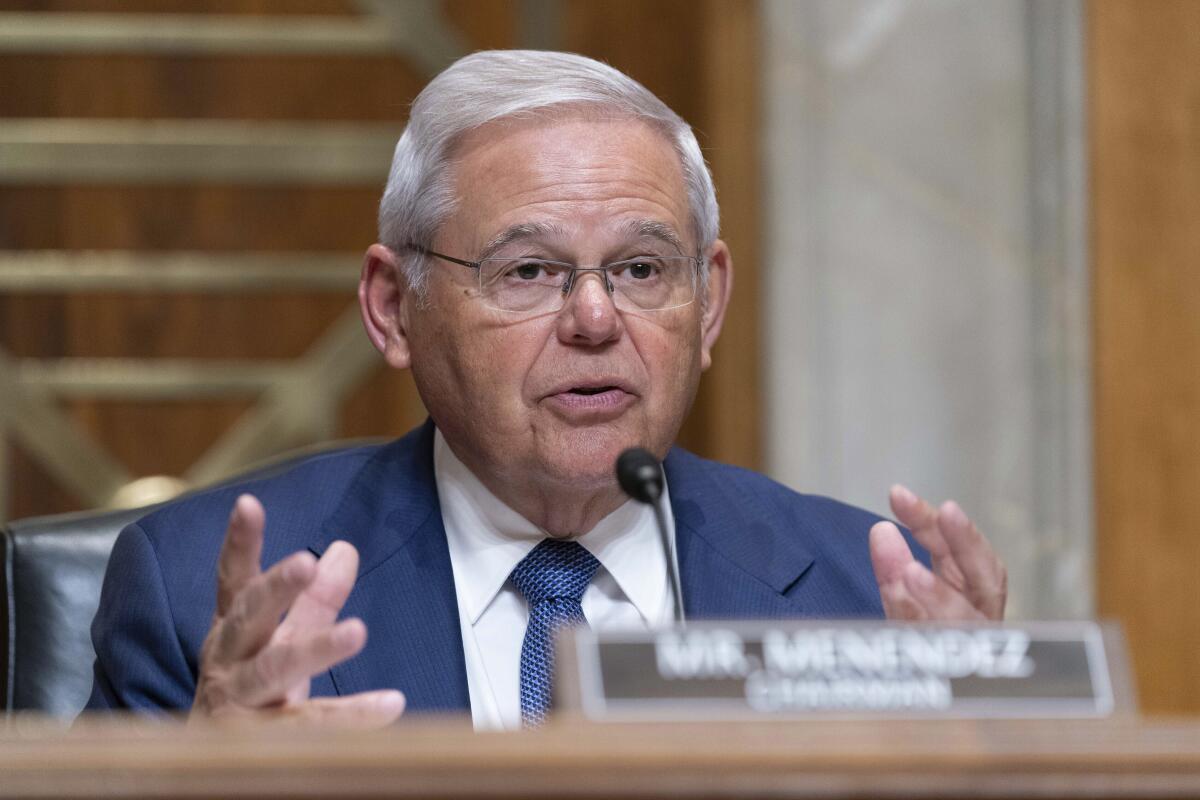 Sen. Robert Menendez sits at a microphone with his nameplate in front of him