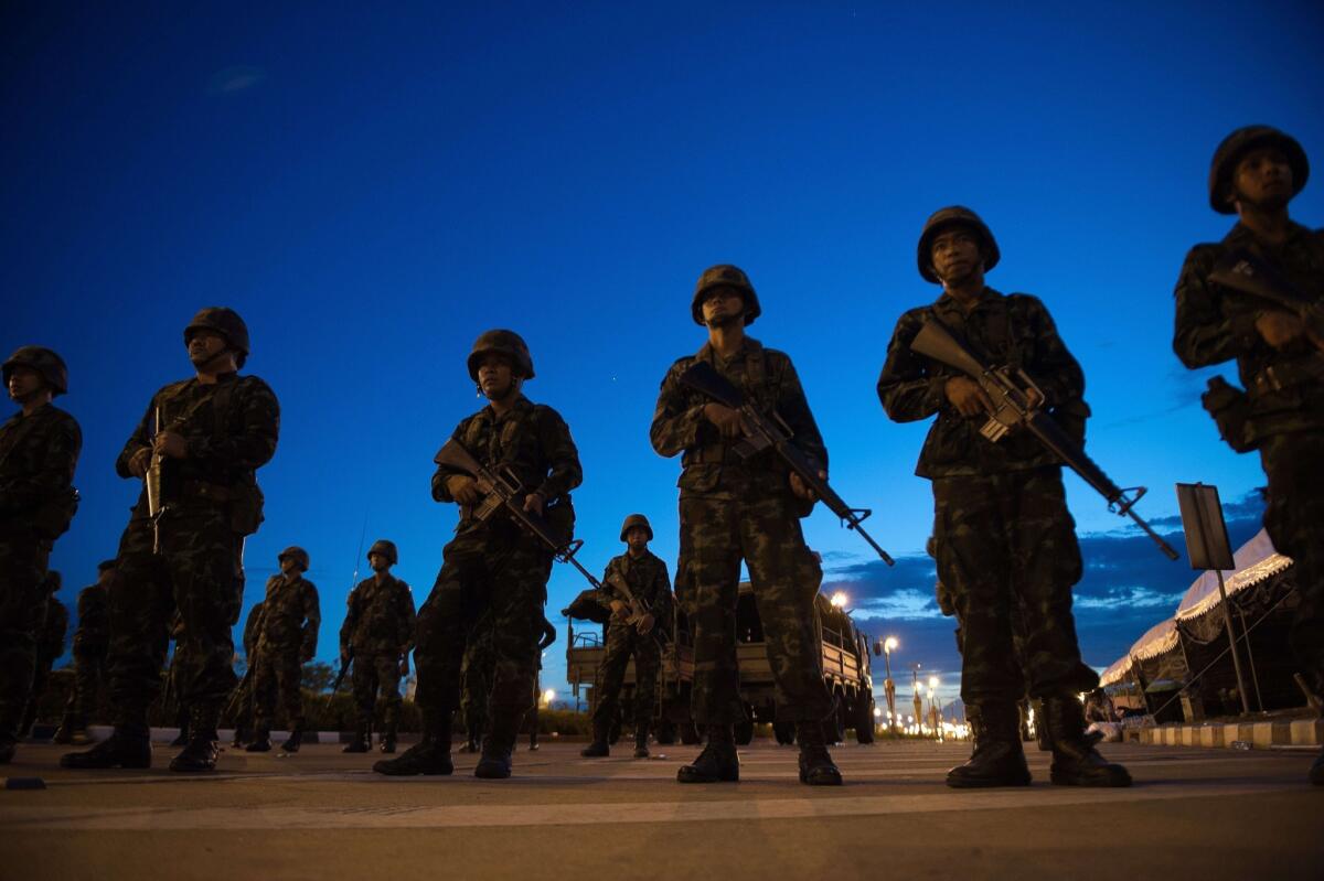 Thai soldiers stand guard at the entrance to a pro-government rally site on the outskirts of Bangkok after the country's armed forces seized power May 22.