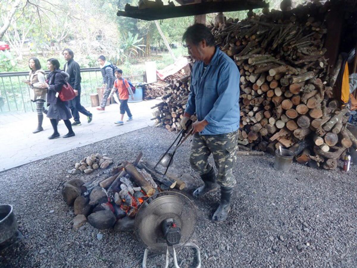 A member of the Amis ethic group prepares a fire for cooking fish for visitors to the Matai'an Wetland Ecological Park in Taiwan.