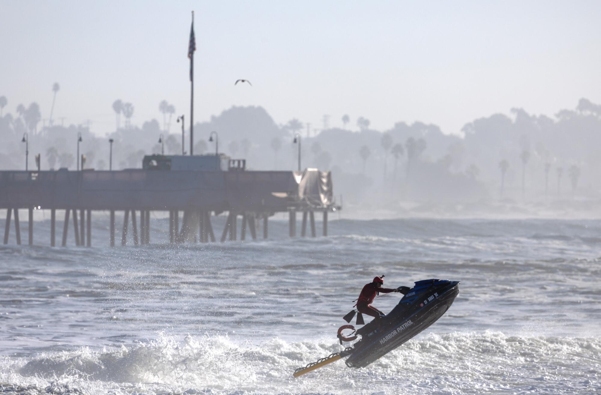 A Harbor Patrol lifeguard jumps a wave near Ventura Pier on Thursday.