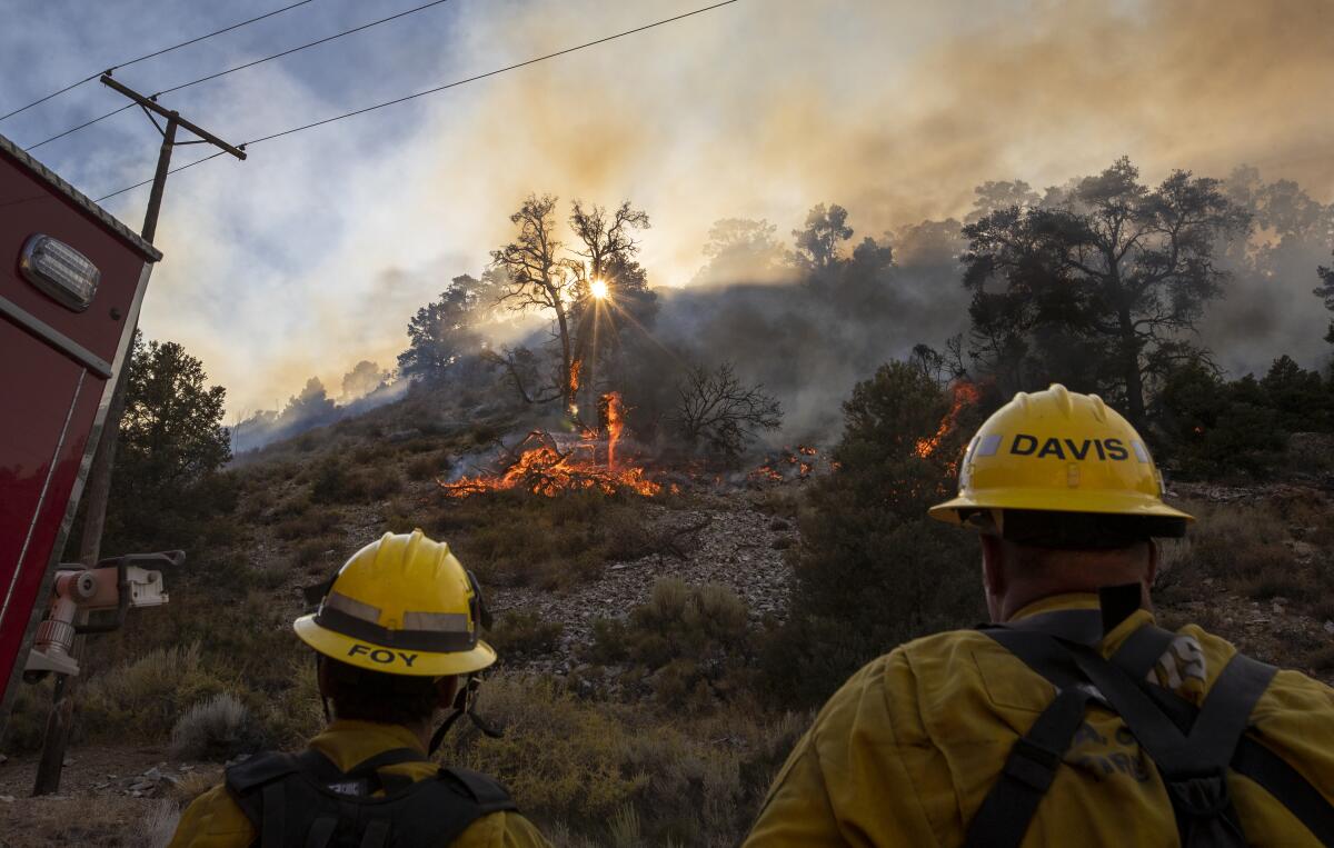 Los Angeles County firefighters watch a flare-up