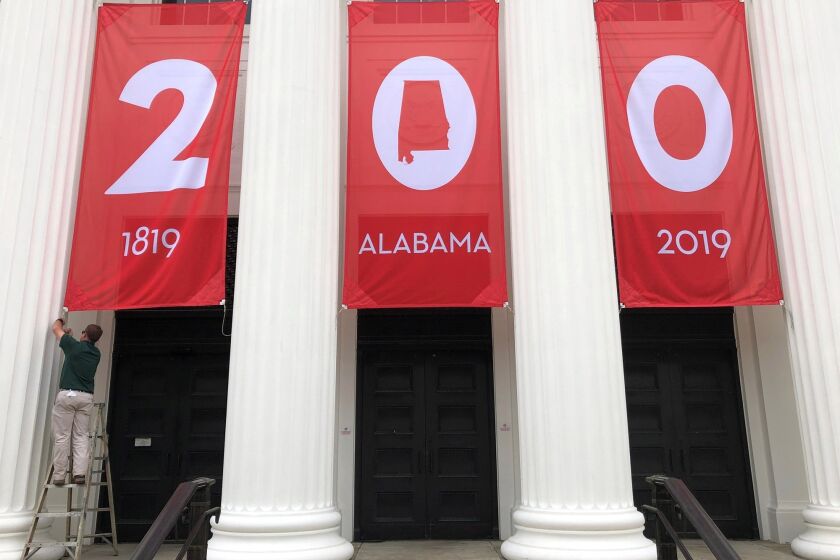 In this Feb. 28, 2019, photo a worker adjusts a banner celebrating Alabama's bicentennial outside the Department of Archives and History in Montgomery, Ala. Alabama's main state history agency is acknowledging that it helped perpetuate systemic racism by promoting Confederate narratives while ignoring those of Black people, a "statement of recommitment" issued Tuesday, June 23, 2020 by the Alabama Department of Archives and History said. (AP Photo/Jay Reeves, File)
