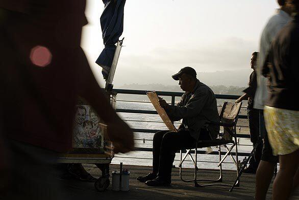 Artist Xiaoyipang makes a portrait of a customer at the Santa Monica Pier.