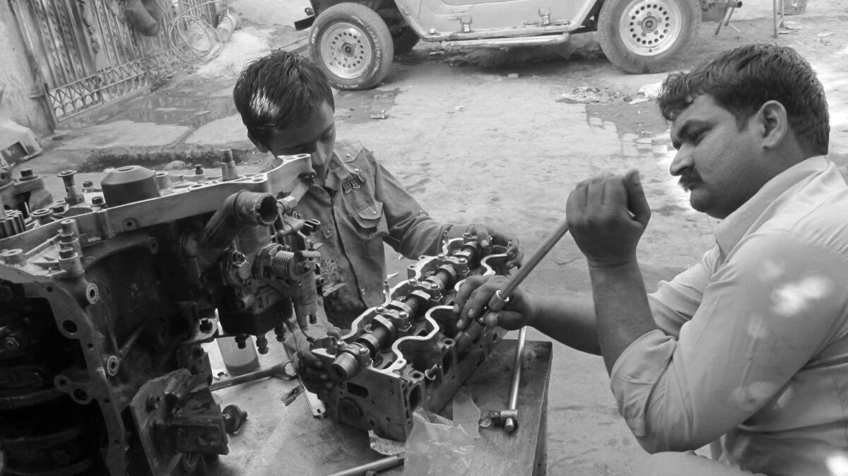 Master mechanic Amjid in Lahore, Pakistan, rebuilding the M151's engine.