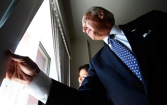 Vice President Joe Biden looks out Herica Galindo's window during a visit to her apartment complex near downtown Los Angeles, which had been contaminated with lead paint. It was rehabilitated by the Esperanza Community Housing Corp., which is getting $875,000 in federal stimulus money to remove toxic paint and other health hazards from 225 homes.