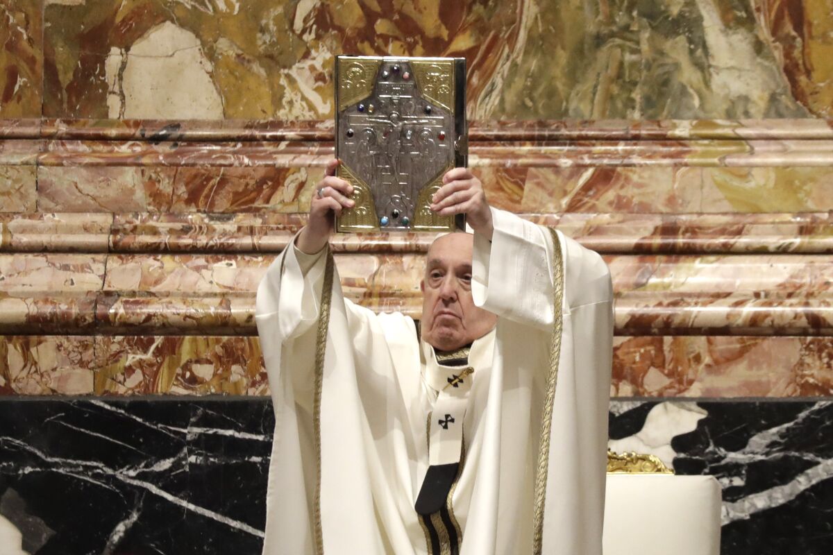 El Papa Francisco sostiene un libro sagrado durante una misa de Jueves Santo en la Basílica de San Pedro