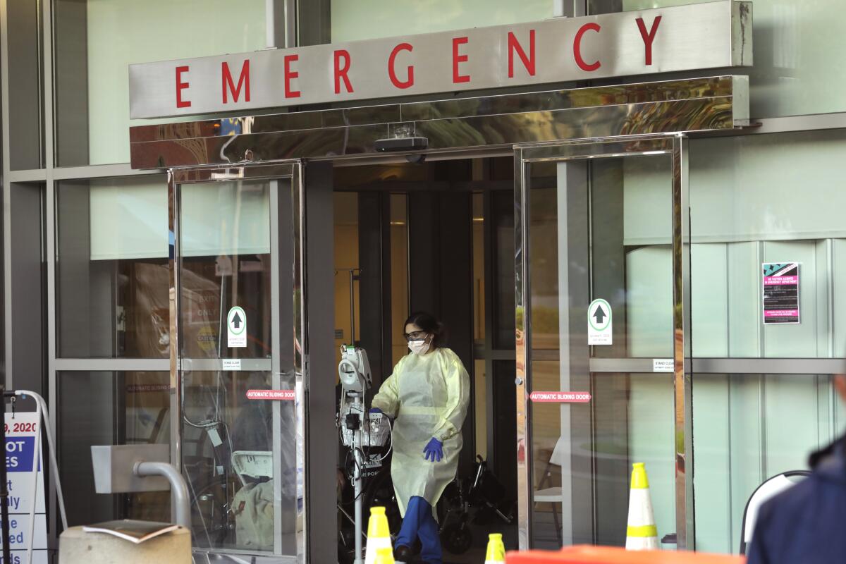 A person in protective gear leaves the UCLA Medical Center emergency room.