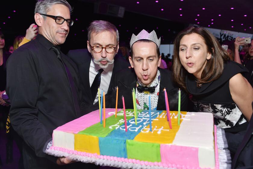 Longchamp Chief Executive Officer Olivier Cassegrain, second from left, designer Jeremy Scott, center, and Longchamp artistic director Sophie Delafontaine blow out the candles on a cake decorated with "Happy 10th Anniversary" at party in the Hollywood Hills.