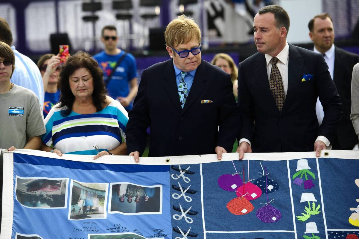 Jeanne White, mother of Ryan White, Elton John, center, and David Furnish with the AIDS Memorial Quilt.