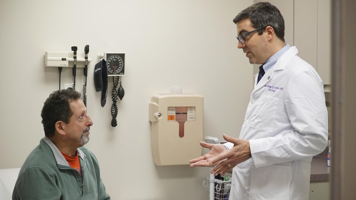 El paciente Daniel Lobello, a la izquierda, habla con el doctor Matthias Hofer, urólogo 