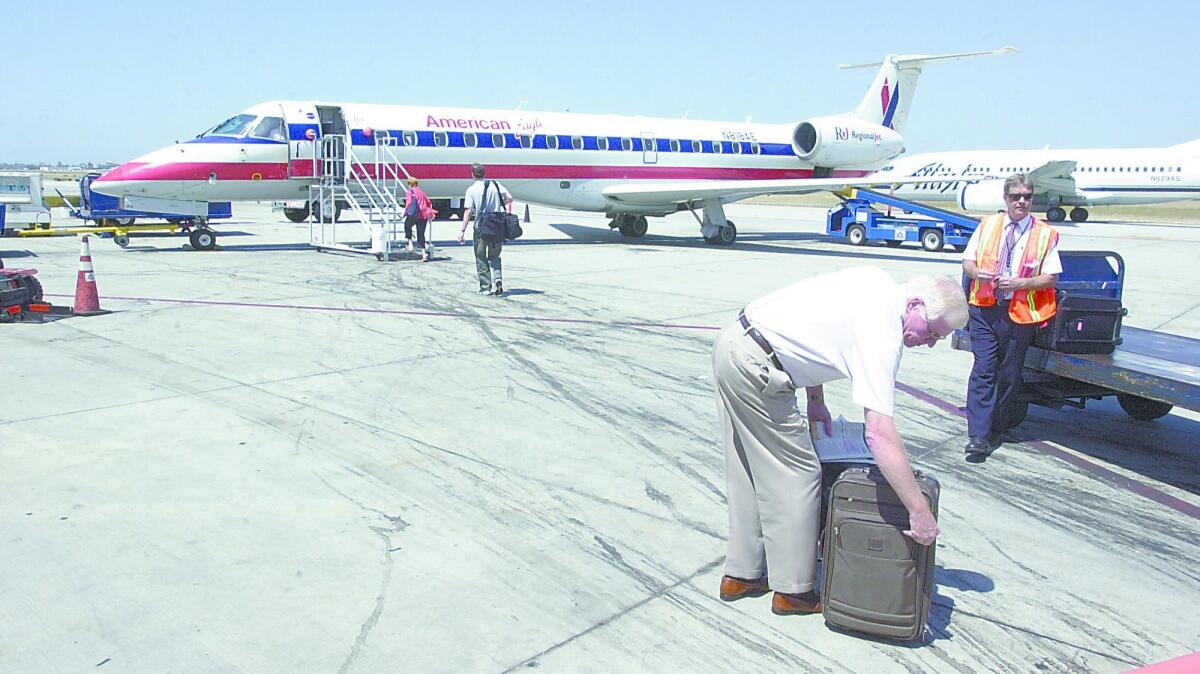 A passenger checks his luggage as he prepares to board a commuter flight at John Wayne Airport.