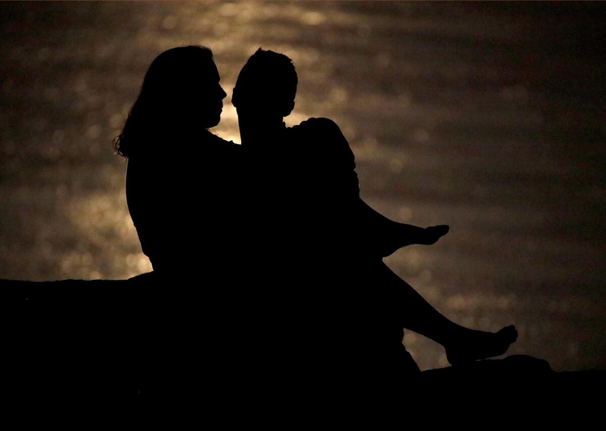 a couple is silhouetted against moonlight 