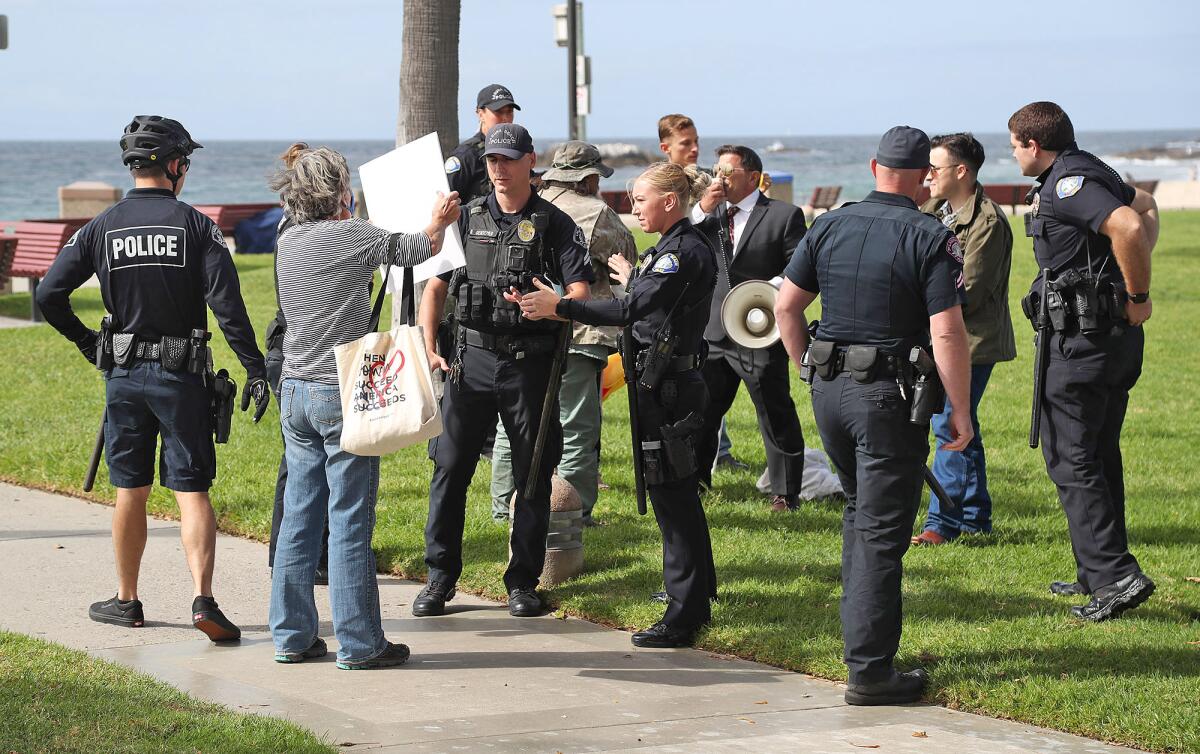 Laguna Beach police keep the peace where a supporter of Jane Fonda, with sign, confronts a Fonda opponent.