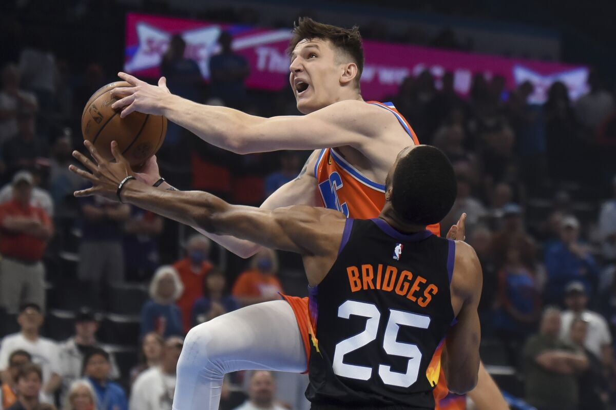 Oklahoma City Thunder guard Vit Krejci, top, is defended by Phoenix Suns forward Mikal Bridges during the first half of an NBA basketball game Sunday, April 3, 2022, in Oklahoma City. (AP Photo/Kyle Phillips)