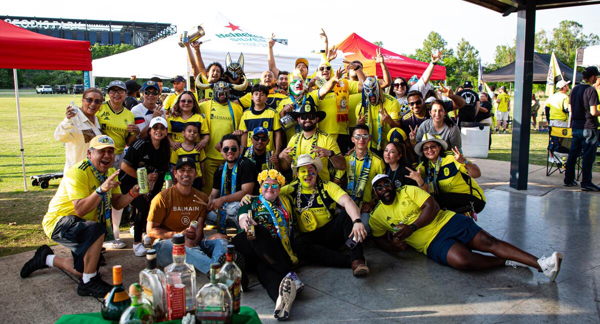 Several members of La Brigada de Oro pose at a tailgate before a Nashville SC match.