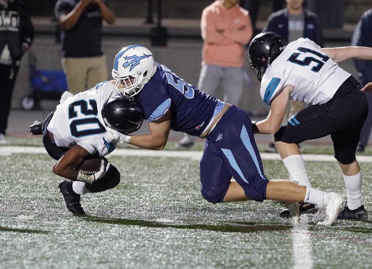 Corona del Mar's Thomas Bouda tackles Santiago's Calin Marshall for a loss in the first round of the CIF Southern Section Division 3 playoffs on Friday at Newport Harbor High.