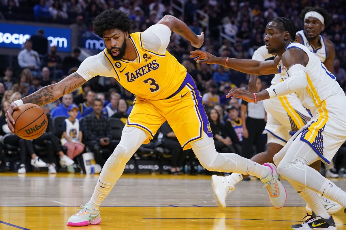 Lakers forward Anthony Davis keeps the ball in play against the Golden State Warriors during the first half Sunday.