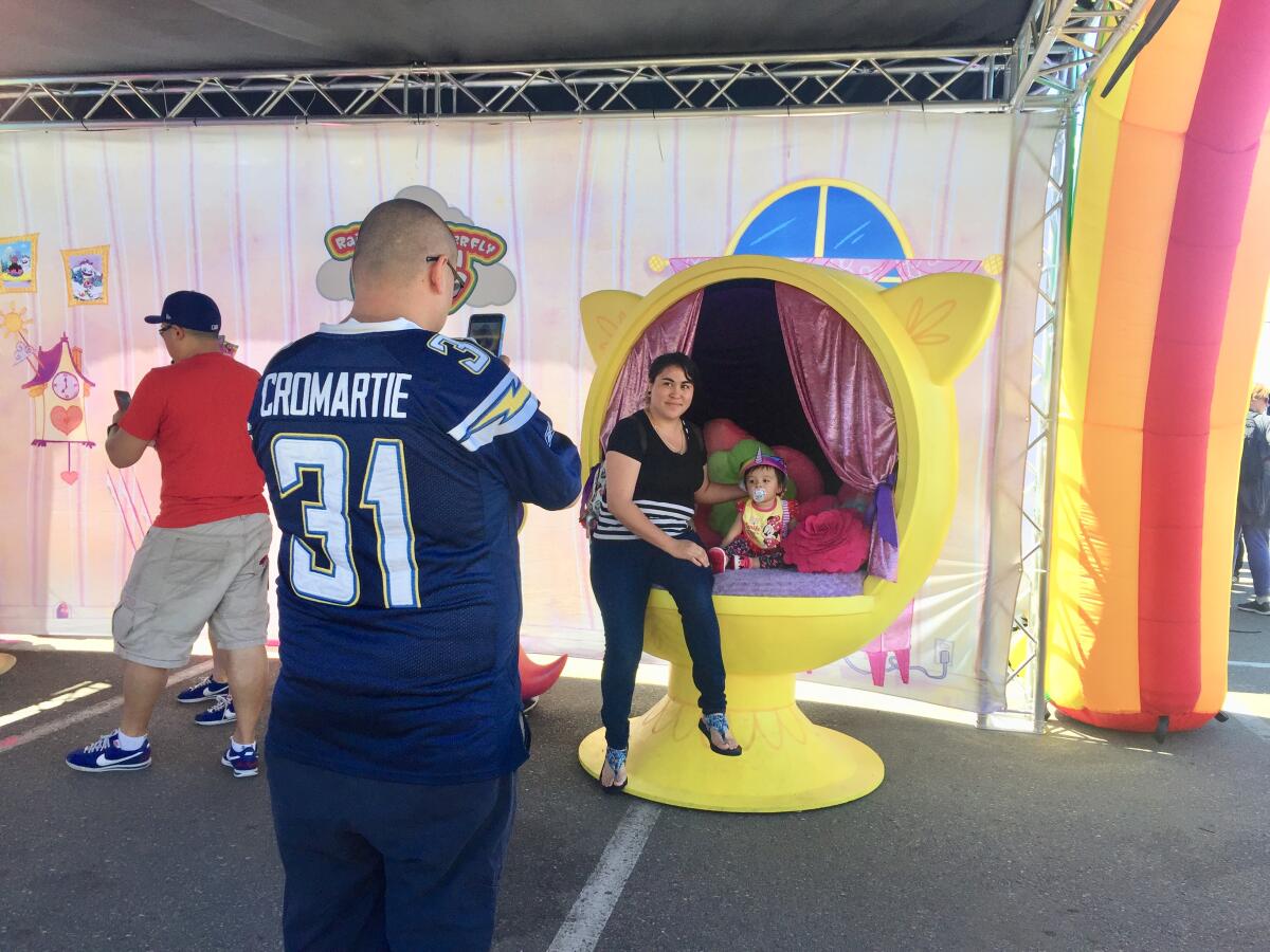 A family enjoys a photo opp in the Rainbow Butterfly Unicorn Kitty booth at the Petco Park Interactive Zone on Friday.