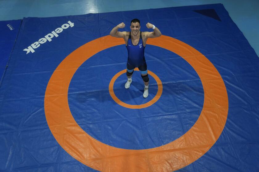 El luchador Iman Mahdavi, integrante del equipo de refugiados para los Juegos Olímpicos de París 2024, posa en un gimnasio en Pioltello, Italia, el 28 de febrero de 2024. (AP Foto/Luca Bruno)