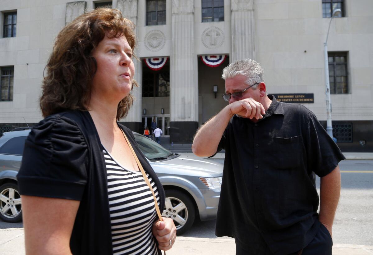 Terry Spurlock, right, of Holly, Mich., a former patient of Dr. Farid Fata, speaks with his wife, Nikii, on Monday outside federal court in Detroit.
