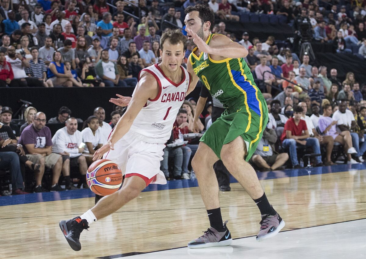 FILE - In this Sept. 13, 2018, file photo, Canada's Kevin Pangos, left, gets by Brazil's Vitor Benite a FIBA Basketball World Cup second-round qualifying game in Laval, Quebec. The Cavaliers signed point guard Pangos to a two-year deal, his agency announced Wednesday, Sept. 8, 2021. The 28-year-old Canadian spent the past six years playing in Europe. (Graham Hughes/The Canadian Press via AP, File)