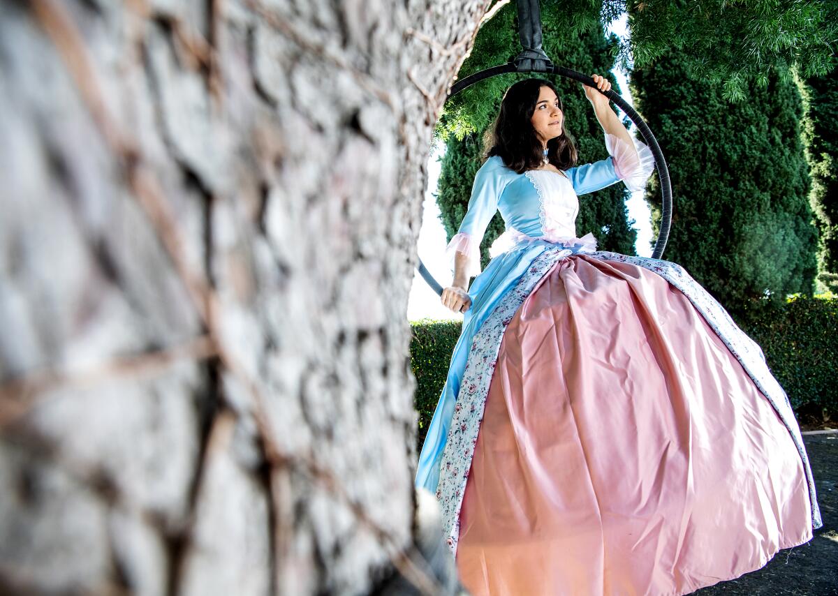 Rose sits on a hoop that hangs from a tree.