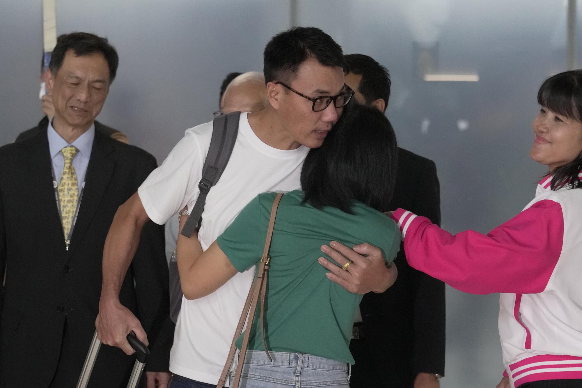 Thai man hugging his wife upon his arrival back in Thailand