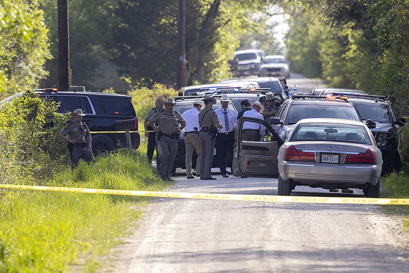 A shooting suspect is apprehended outside a residence in Bedias, Texas, on Thursday.