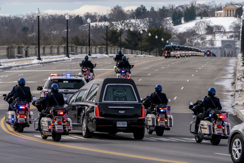 A hearse carrying the body of U.S. Capitol Police officer Brian Sicknick makes its way to Arlington National Cemetery