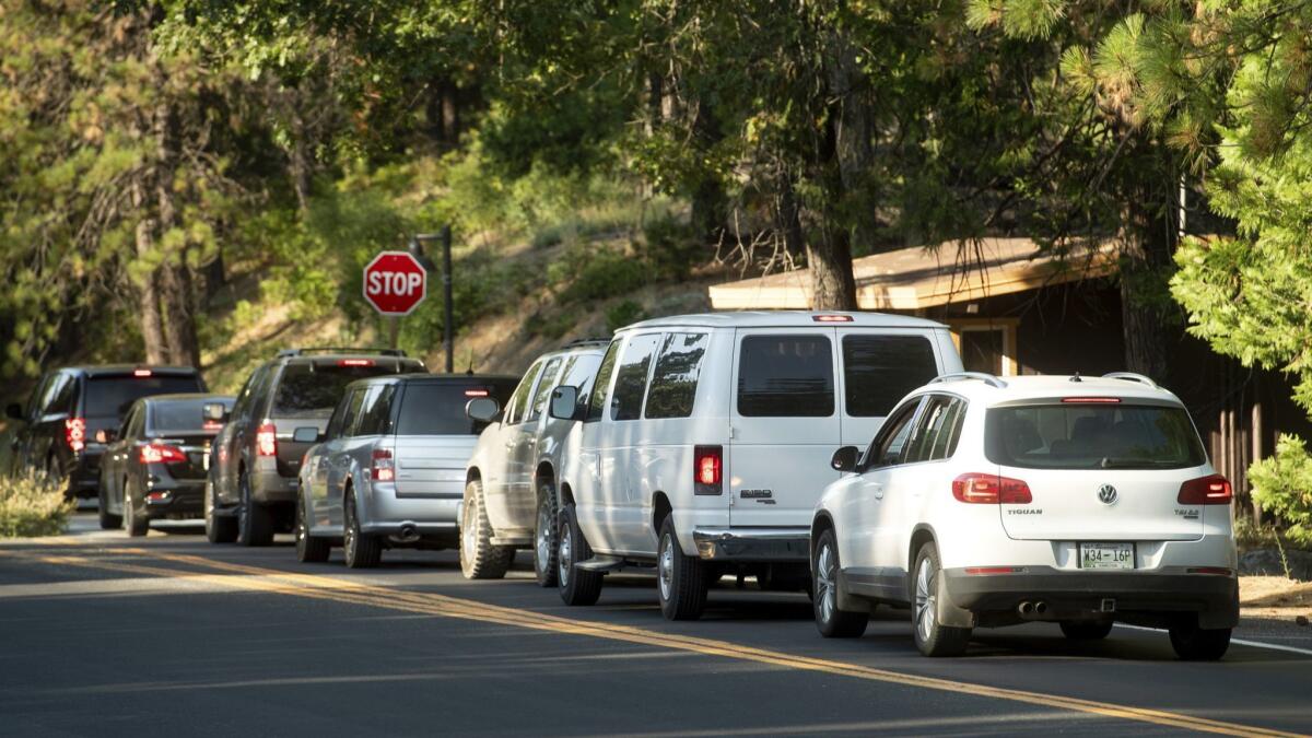 Vehicles leave Yosemite National Park on Tuesday as the Ferguson fire burns nearby. Parts of the park, including Yosemite Valley, closed Wednesday as firefighters work to stop the blaze.