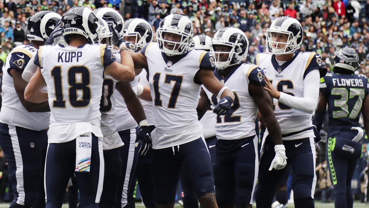 Rams wide receivers Cooper Kupp (18), Robert Woods (17), Brandin Cooks (12) and quarterback Jared Goff (16) surround running back Todd Gurley (30) after a touchdown against the Seattle Seahawks.