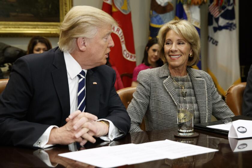 FILE - In this Tuesday, Feb. 14, 2017 file photo, President Donald Trump looks at Education Secretary Betsy DeVos as he speaks during a meeting with parents and teachers in the Roosevelt Room of the White House in Washington. A schism between wealthy funders over private-school vouchers became visible in 2017 during the confirmation process for DeVos, a billionaire heiress who was nominated by Trump for education secretary despite having no experience as a teacher or school administrator. DeVos attended private religious schools in Michigan. Her children were homeschooled and attended religious schools. (AP Photo/Evan Vucci)