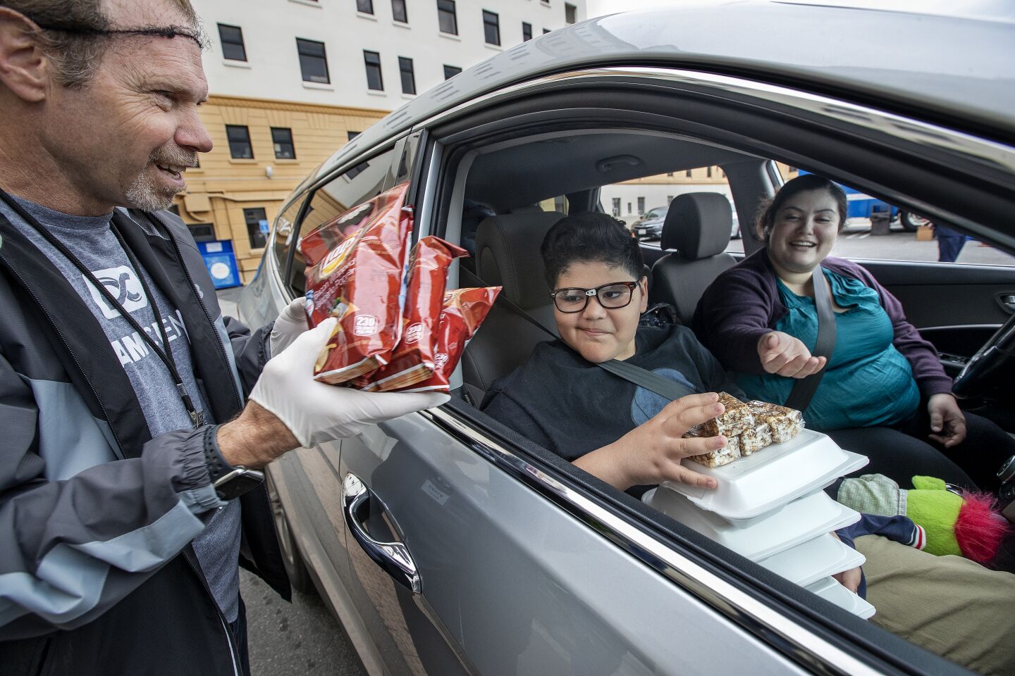 A worker hands out to-go food at Dream Center in L.A.