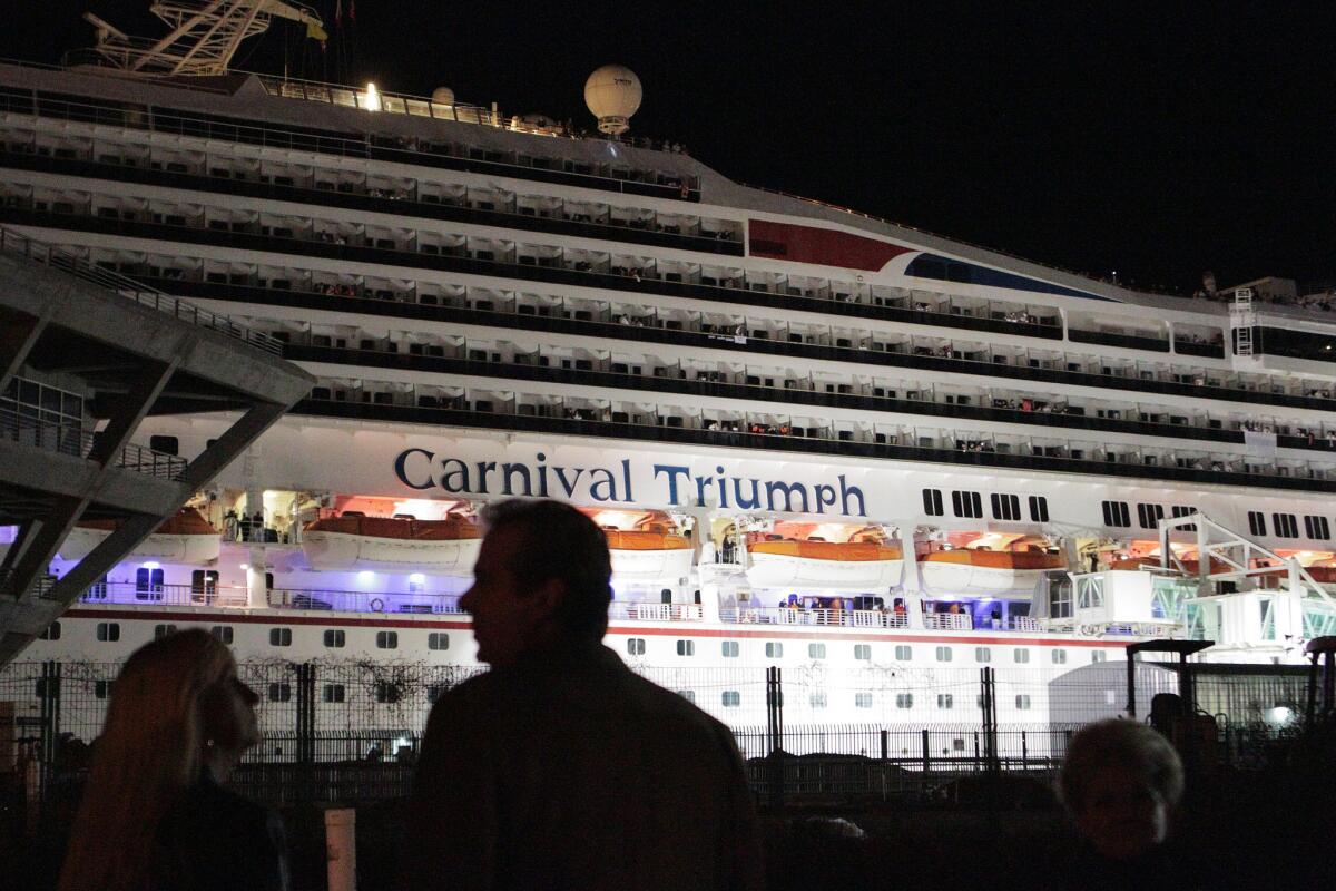 People stand before the docked Carnival ship Triumph in front of the Alabama Cruise Terminal in Mobile, Ala., on Feb. 14, 2013.
