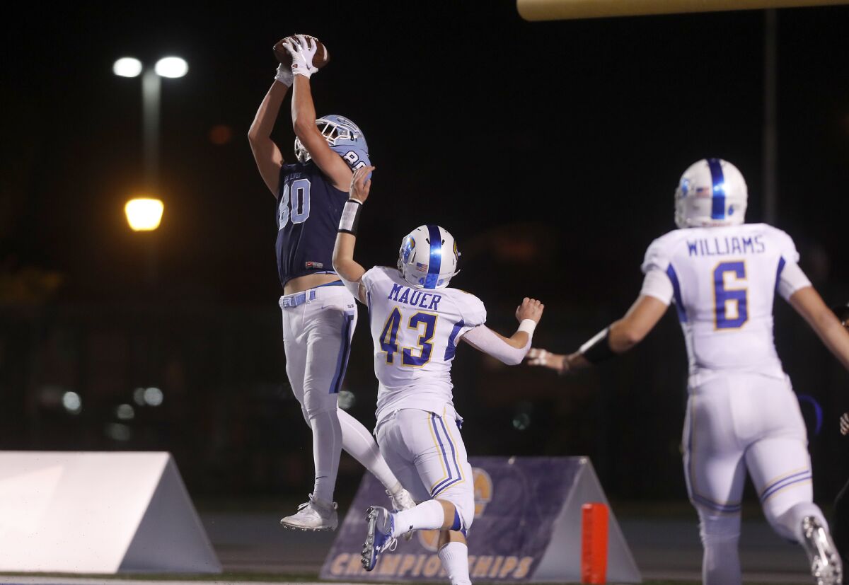 Corona del Mar's Scott Giuliano, left, catches a six-yard touchdown pass over Serra's William Mauer in the third quarter of the CIF State Division 1-A title game on Saturday at Cerritos College.