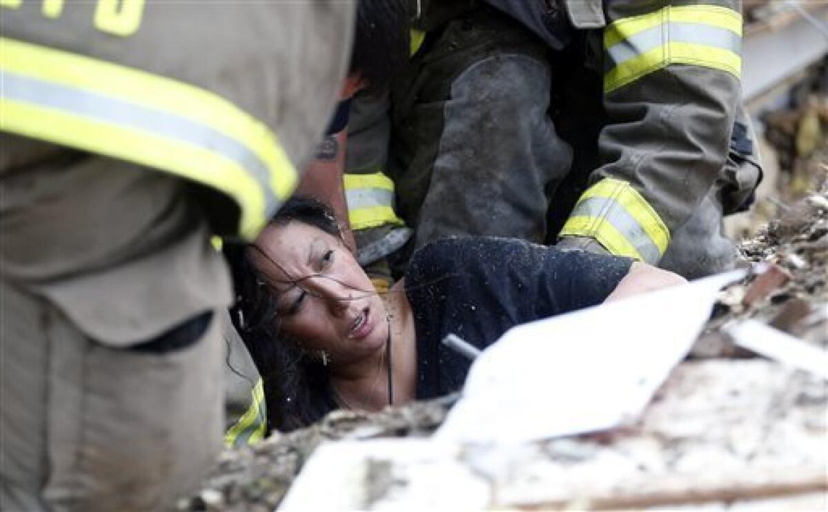 A woman is pulled from tornado debris at the Plaza Towers Elementary School in Moore, Okla.