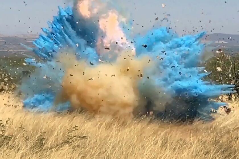 In this frame grab from a April 23, 2017, video provided by the U.S. Forest Service, is a gender reveal event in the Santa Rita Mountain's foothills, more than 40 miles southeast of Tucson, Ariz. The explosion from the reveal ignited the 47,000-acre Sawmill Fire. Gender reveal parties with a blast of color, pink or blue, that were once considered private gatherings have become social media spectacles, sometimes with dangerous consequences. (U.S. Forest Service via AP)