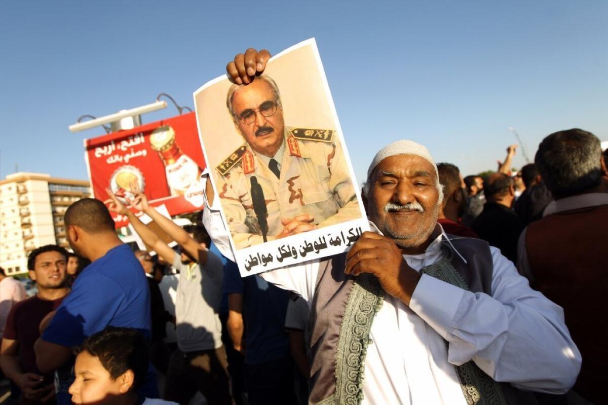 A Libyan man is seen last week carrying a portrait of Khalifa Haftar during a rally in Benghazi in support of the rogue former general whose forces have launched a "dignity" campaign to crush jihadist militias.
