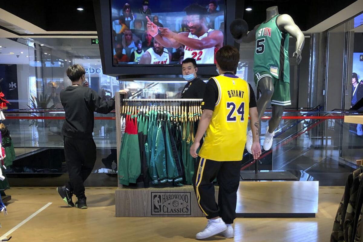 Employees watch a live broadcast of Game 5 of the NBA Finals at an NBA store in Beijing on Saturday.