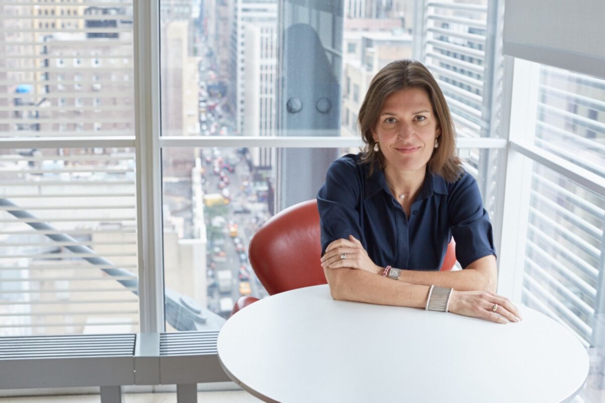 A woman with brown hair sitting at a round white table.