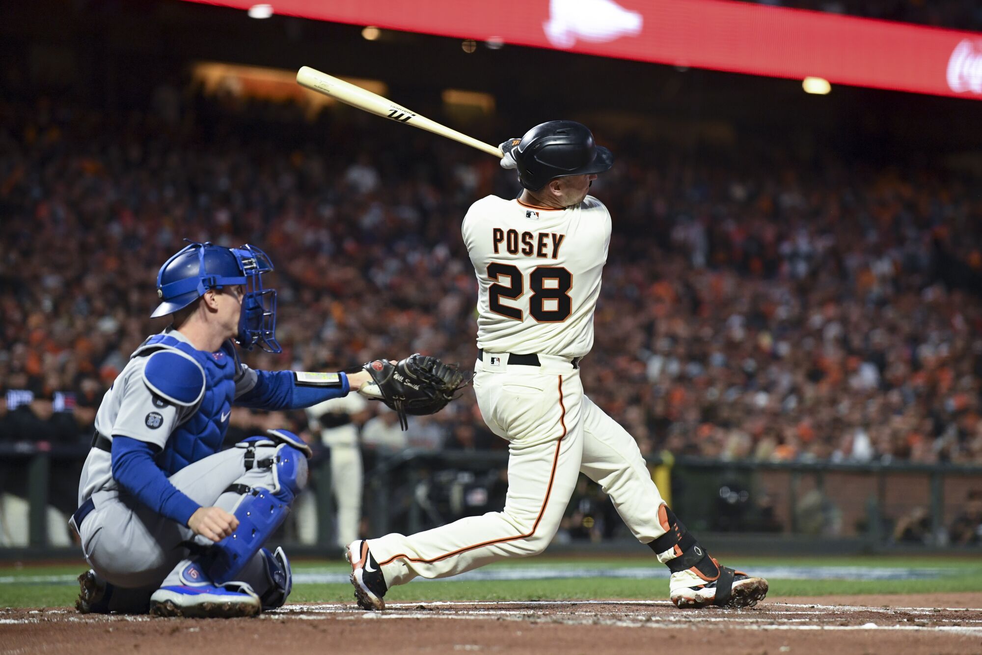 San Francisco Giants' Buster Posey follows through on a swing for a two-run home run