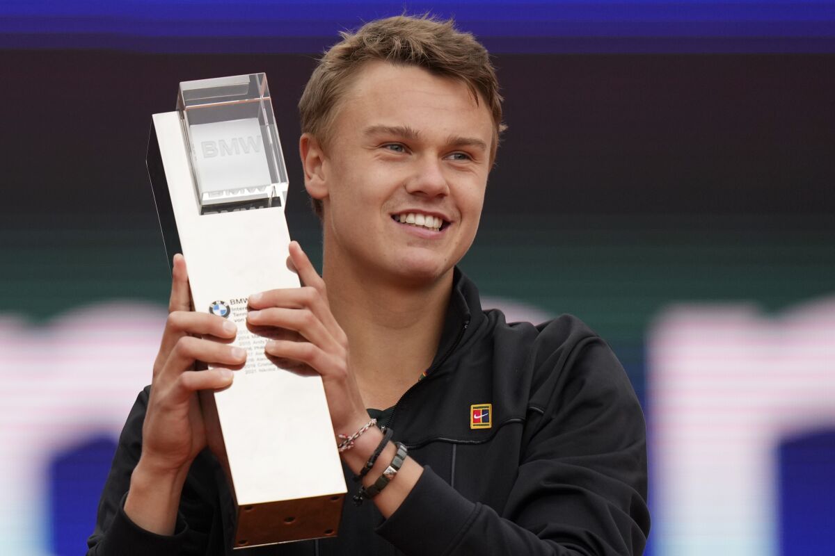 Holger Rune of Denmark lifts the trophy after winning the final match against Botic Van De Zandschulp of the Netherlands at the Tennis ATP tournament in Munich, Germany, Sunday, May 1, 2022. (AP Photo/Matthias Schrader)
