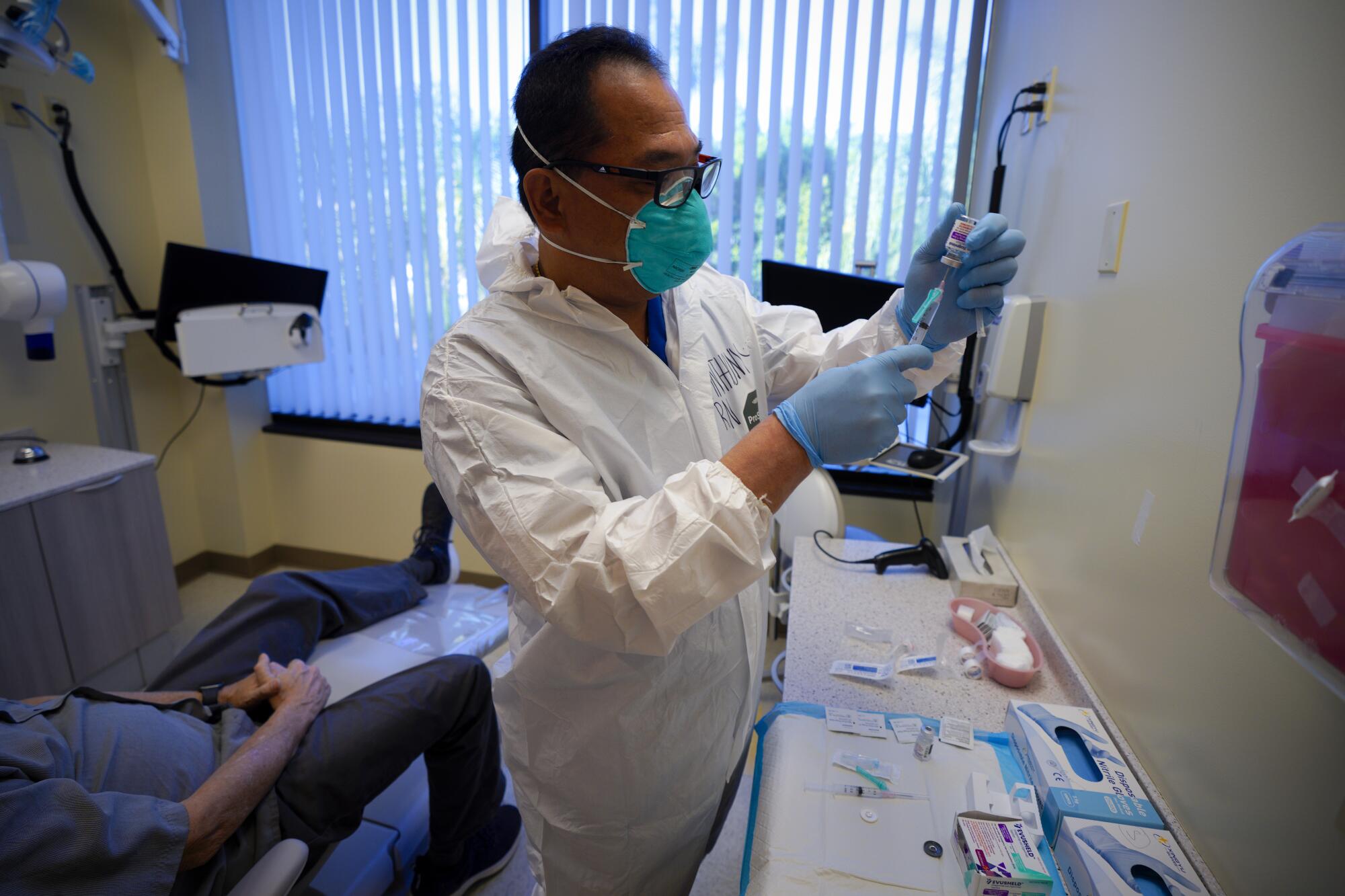 RN Anthony Baysa prepares one of two syringes containing the long-acting monoclonal antibody .