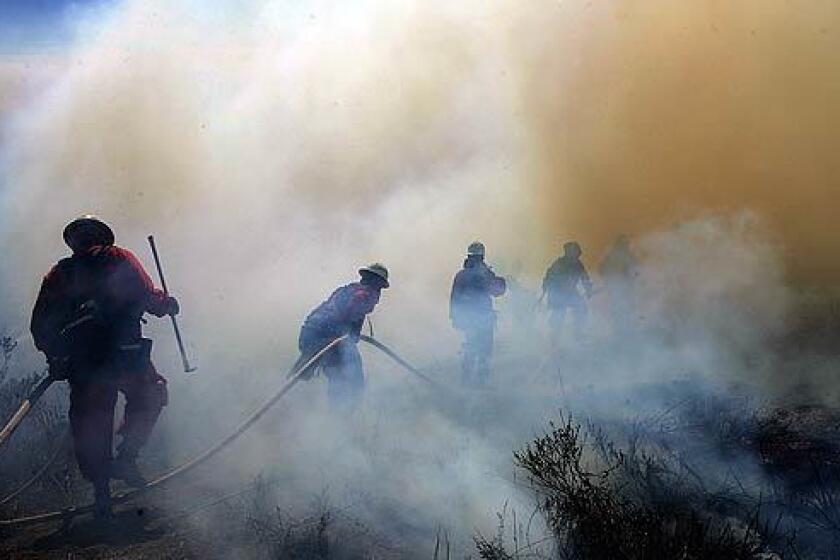 Crews forge their way through thick smoke in Las Flores Canyon in the Malibu area.