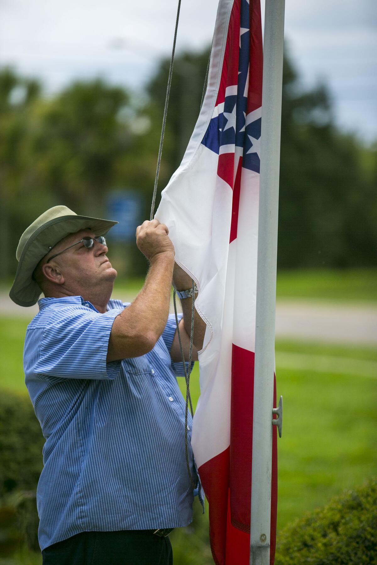 Vic Pollock, trabajador de mantenimiento del condado Marion, ata la bandera confederada a un asta afuera del Complejo Gubernamental McPherson, en Ocala, Florida, el martes 7 de julio de 2015. (Foto de Alan Youngblood/Ocala Star-Banner vía AP)