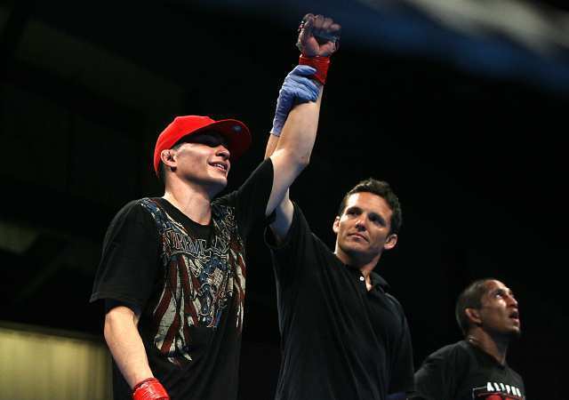 Isaac Gutierrez has his hand raised in victory over Carlos Garces in a mixed martial arts fight at the Fight Club OC in the Hangar at the Orange County Fairgrounds and Event Center.