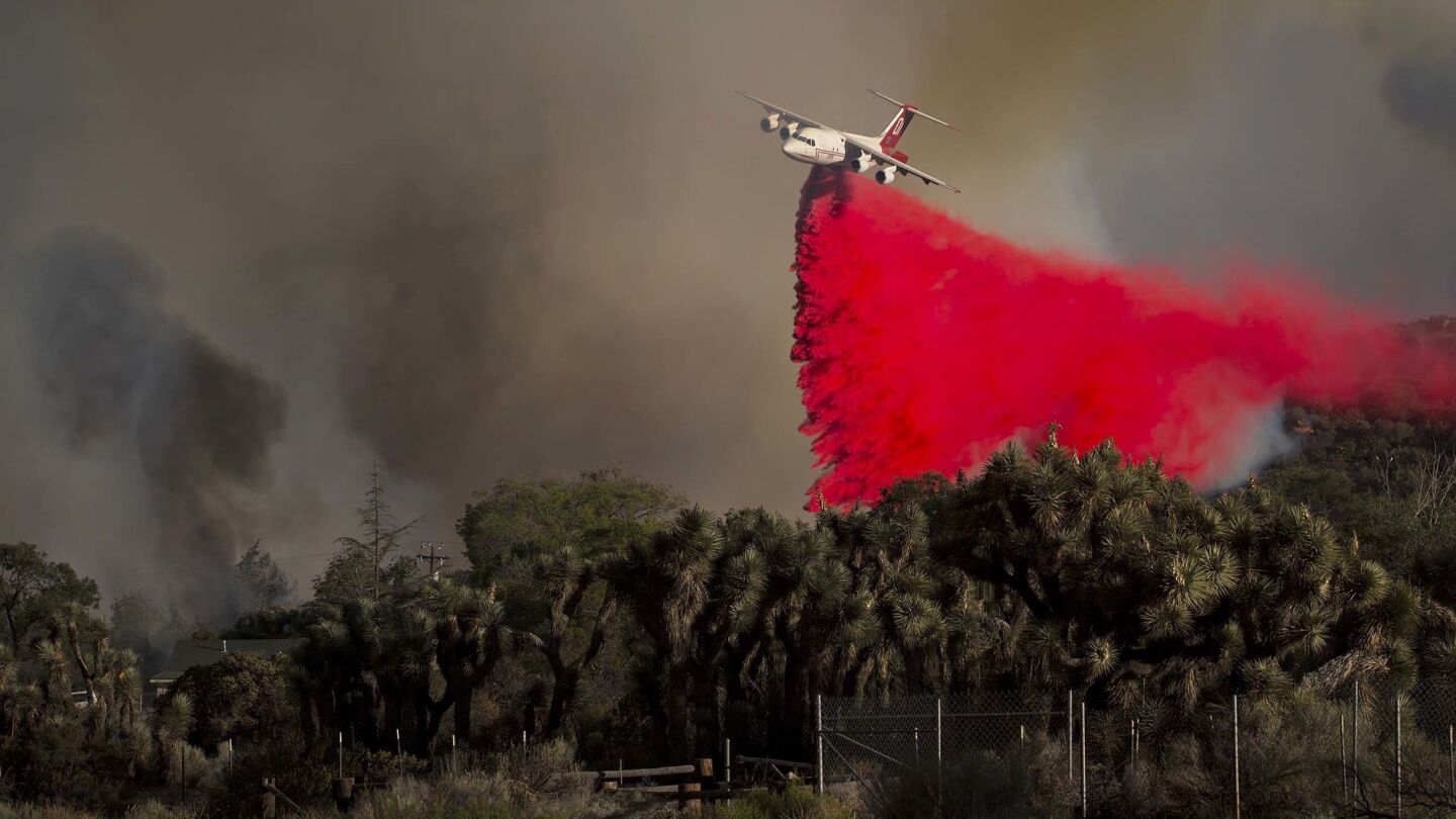 An air tanker drops fire retardant near homes as the Blue Cut fire burns out of control on both sides of Highway 138 in Summit Valley, California.