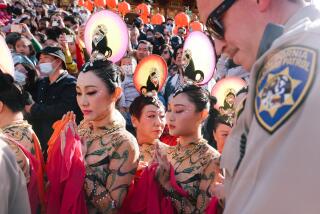 Hacienda Heights, CA - January 22: A state law enforcement agent passes a group of dancers before their performance during a celebration of the Chinese Lunar New Year at the Hsi Lai Temple on Sunday, Jan. 22, 2023 in Hacienda Heights, CA. (Dania Maxwell / Los Angeles Times).
