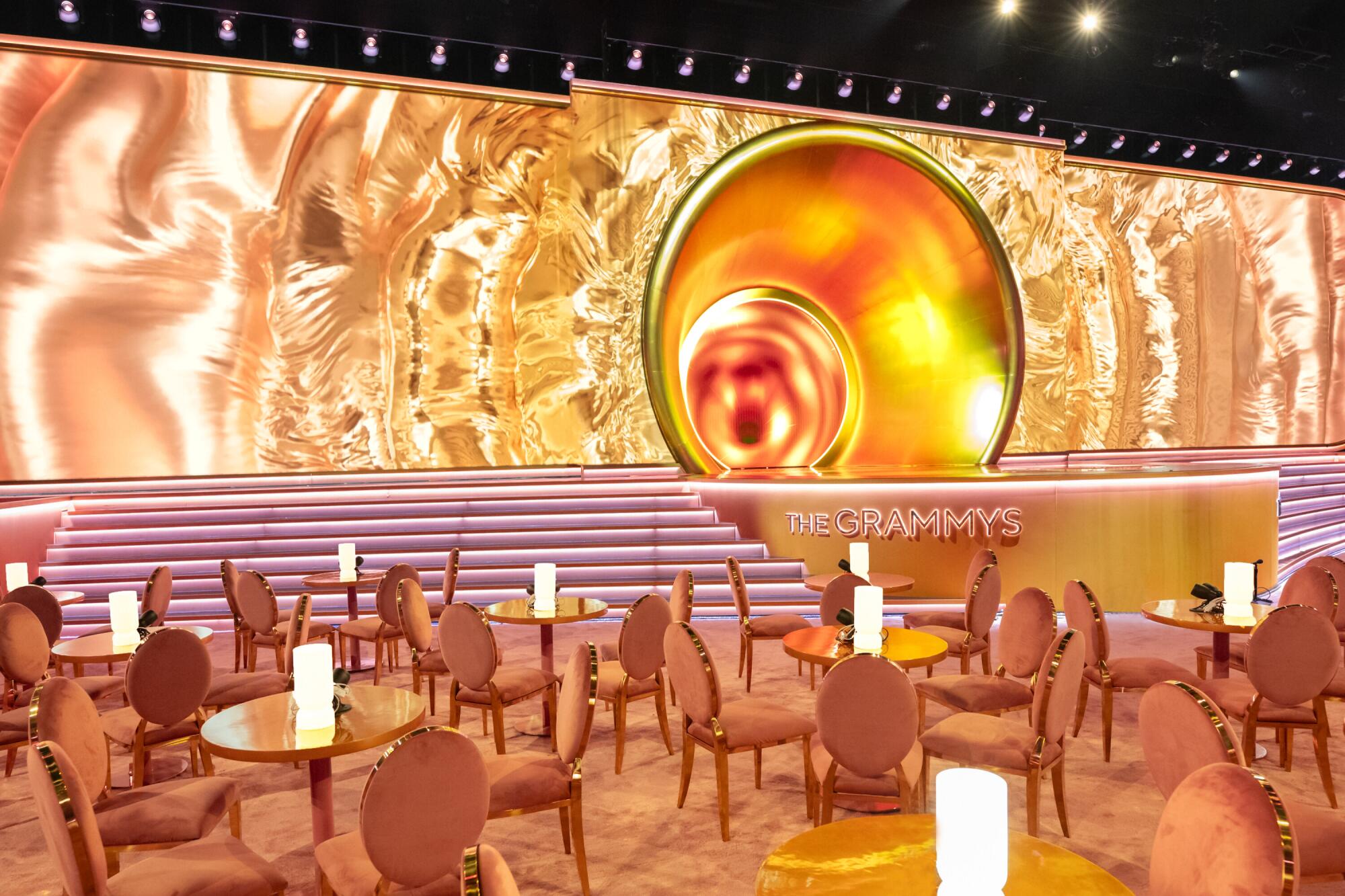 Cabaret-style tables and chairs at the foot of the gold-decorated stage for the 66th Grammy Awards.